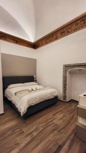 een slaapkamer met een groot bed en houten vloeren bij Duomo Holiday in Napels