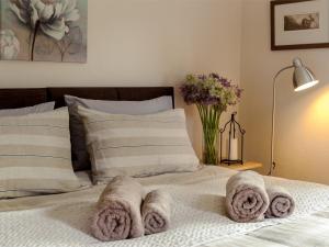 a bed with towels on it with a vase of flowers at 1 bed in Builth Wells BN201 in Aberedw