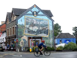 a man riding a bike in front of a building with a mural at 1 bed in Builth Wells BN201 in Aberedw