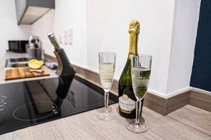 uma garrafa de champanhe e dois copos no balcão em Luxury City Centre Apartment with Juliet Balcony, Fast Wifi and SmartTV with Netflix by Yoko Property em Aylesbury