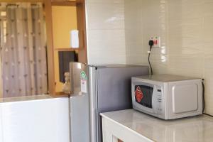 eine Mikrowelle auf einer Theke neben einem Kühlschrank in der Unterkunft Fin & Dee 2 in Ruiru