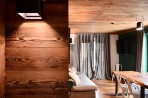 a living room and a dining room with wood walls at Residenza Du Parc in Sauze dʼOulx