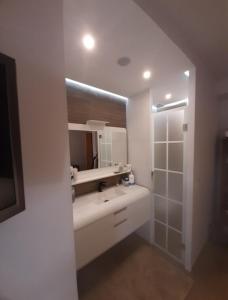Baño blanco con lavabo y espejo en Comodidad en primera linea de playa, en Benalmádena