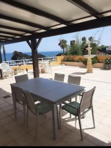 un tavolo e sedie su un patio con vista sull'oceano di Comodidad en primera linea de playa a Benalmádena