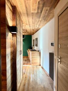 a hallway with a wooden ceiling and a kitchen at Residenza Du Parc in Sauze dʼOulx