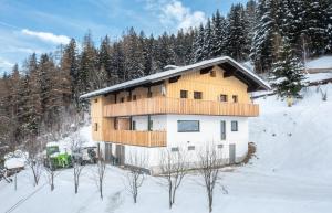 een huis in de sneeuw met een groene truck voor de deur bij Appartements Uribi mit eigener Sauna by Schladmingurlaub in Schladming