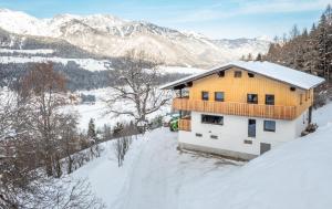 een huis in de sneeuw met bergen op de achtergrond bij Appartements Uribi mit eigener Sauna by Schladmingurlaub in Schladming