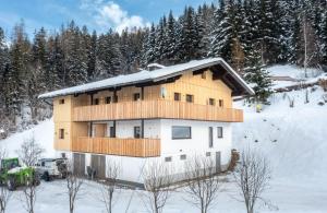 een huis in de sneeuw met een vrachtwagen bij Appartements Uribi mit eigener Sauna by Schladmingurlaub in Schladming