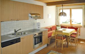 uma cozinha com um lavatório e uma mesa com uma sala de jantar em Awesome Apartment In Pettneu Am Arlberg With Wifi em Pettneu am Arlberg