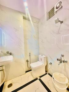 uma casa de banho branca com um WC e um lavatório em HOTEL EAGLE GRAND em Shamshabad