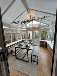 Salón acristalado con mesa en una habitación con ventanas en Stamford House - Short Stays and Contractors, en Lincolnshire