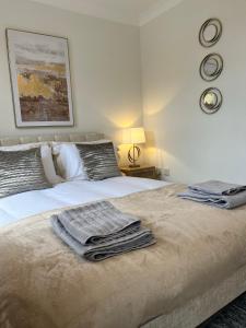 1 dormitorio con 1 cama con toallas en Stamford House - Short Stays and Contractors, en Lincolnshire