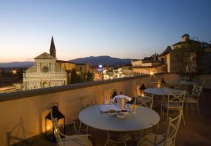 due tavoli su un balcone con vista sulla città di Santa Maria Novella - WTB Hotels a Firenze
