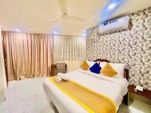 um quarto com uma cama grande e uma televisão na parede em HOTEL EAGLE GRAND em Shamshabad