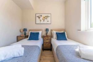 two beds in a room with blue and white at Central Coventry Apartment in Coventry