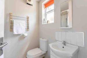 a white bathroom with a toilet and a sink at Central Coventry Apartment in Coventry
