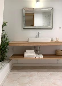 W łazience znajduje się umywalka i lustro. w obiekcie La Place B&B w mieście Sancerre