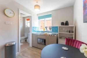 a kitchen with a table and a counter top at Central Coventry Apartment in Coventry