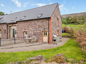 a brick house with a patio and a table at 1 bed property in Tretower Brecon Beacons BN126 