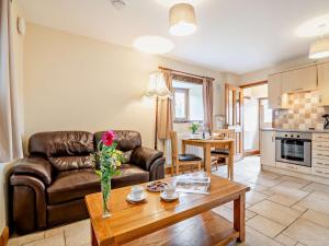 a living room with a leather couch and a table at 1 bed property in Tretower Brecon Beacons BN126 