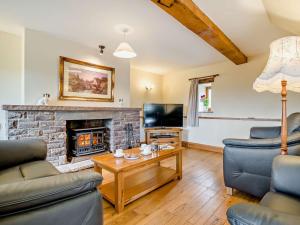 a living room with a fireplace and a tv at 3 bed in Tretower BN124 