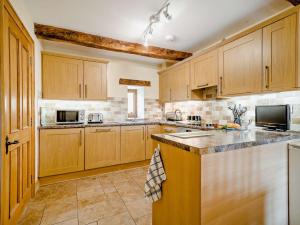 a kitchen with wooden cabinets and a counter top at 3 bed in Tretower BN124 