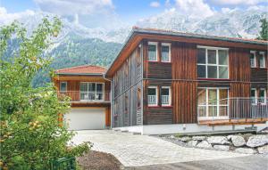una gran casa de madera con montañas en el fondo en Gorgeous Apartment In Ausserbraz With Kitchen, en Ausserbraz