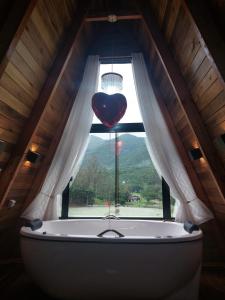 a heart shaped window with a tub in a attic at Vista dos Canyons in Praia Grande