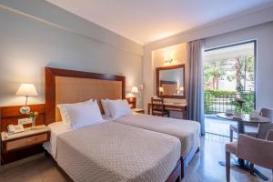 una camera d'albergo con un letto e un balcone di JOHN & GEORGE a Tolo