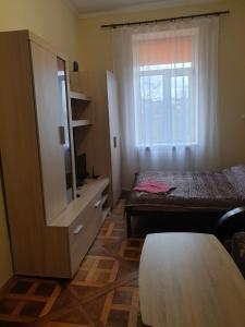 um pequeno quarto com uma cama e uma janela em Apartment on Lysenka 27 em Lviv