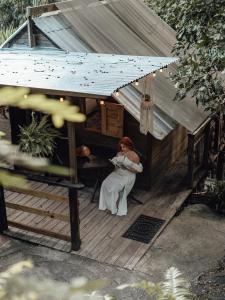 a woman sitting in the doorway of a house at Hacienda Tres Casitas in Cabo Rojo