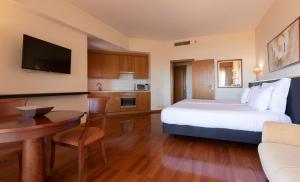 a hotel room with a bed and a table and a kitchen at MS Aparthotel in Linda-a-Velha