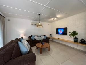 a living room with two couches and a tv at Pompano Corner in Richards Bay