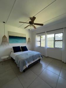 1 dormitorio con 1 cama y ventilador de techo en Pompano Corner, en Richards Bay