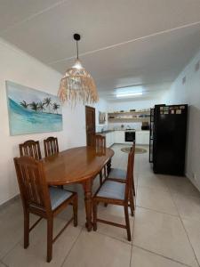 a dining room with a wooden table and chairs at Pompano Corner in Richards Bay