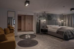 a bedroom with a bed and a couch and a table at Hotel Madlein in Ischgl