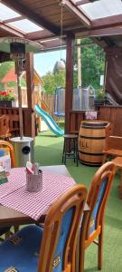 a patio with a table and chairs and a playground at Rodinný pension U Soudku in Rudník