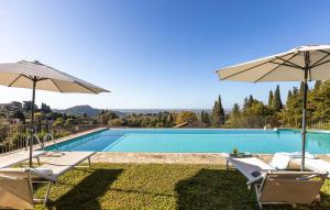 a swimming pool with two chairs and an umbrella at Al Frantoio in Corsanico-Bargecchia
