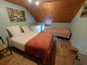 a bedroom with two beds and a wooden ceiling at Le Vieux La Roche in La Roche-en-Ardenne