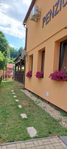 a building with flowers on the side of it at Rodinný pension U Soudku in Rudník