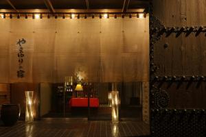 a room with a table and a red bench and lights at Yamayuri no Yado in Hanamaki