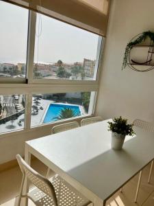 einen weißen Tisch und Stühle in einem Zimmer mit Fenster in der Unterkunft relax in Candelaria