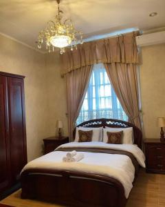 a bedroom with a large bed with a chandelier and a window at Casa Setra Bandung in Bandung