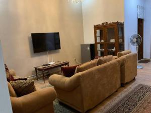 a living room with couches and a flat screen tv at Casa Setra Bandung in Bandung