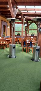 un restaurante con mesas y sillas de madera y alfombra verde en Rodinný pension U Soudku en Rudník