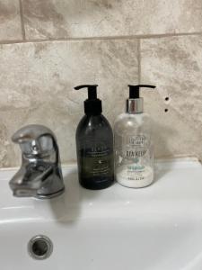 two soap bottles sitting on top of a bathroom sink at 3-Bedroom Apartment In The Heart of London in London