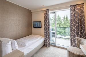 Schlafzimmer mit einem Bett und einem Fenster in der Unterkunft Thomas Hotel Spa & Lifestyle in Husum