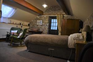 ein Schlafzimmer mit einem großen Bett und einer Steinmauer in der Unterkunft The Barn at the Mill in Selattyn