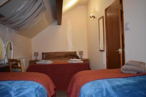 ein Hotelzimmer mit 2 Betten und einem Spiegel in der Unterkunft The Barn at the Mill in Selattyn
