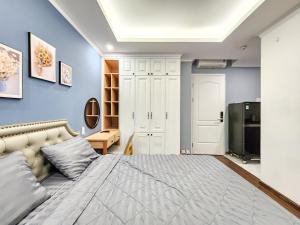 胡志明市的住宿－Golden Sun Hotel Apartments，一间卧室配有一张带蓝色墙壁的大床